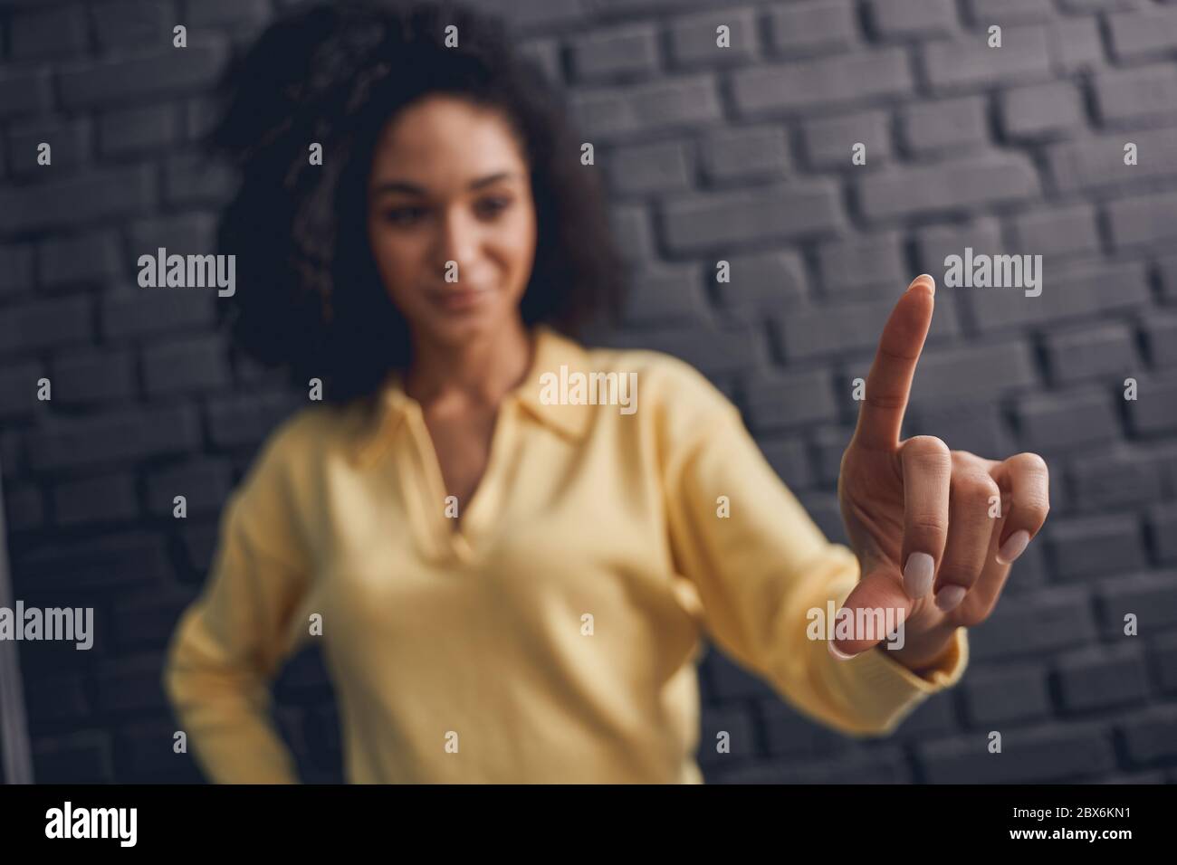 Dark-haired young female making a hand gesture Stock Photo