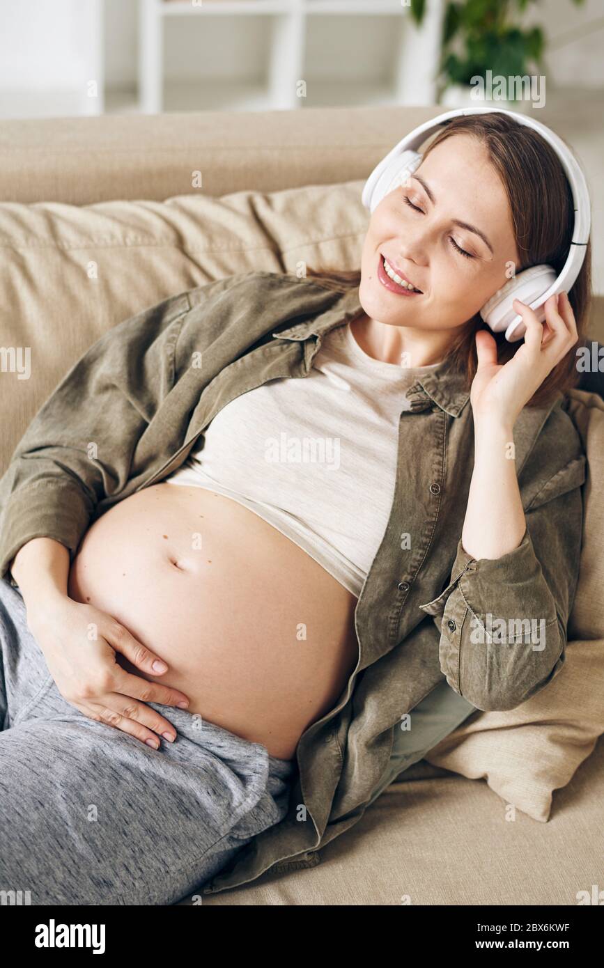 Premium Photo  Pregnant woman putting headphones on her belly concept of  listening music before birth