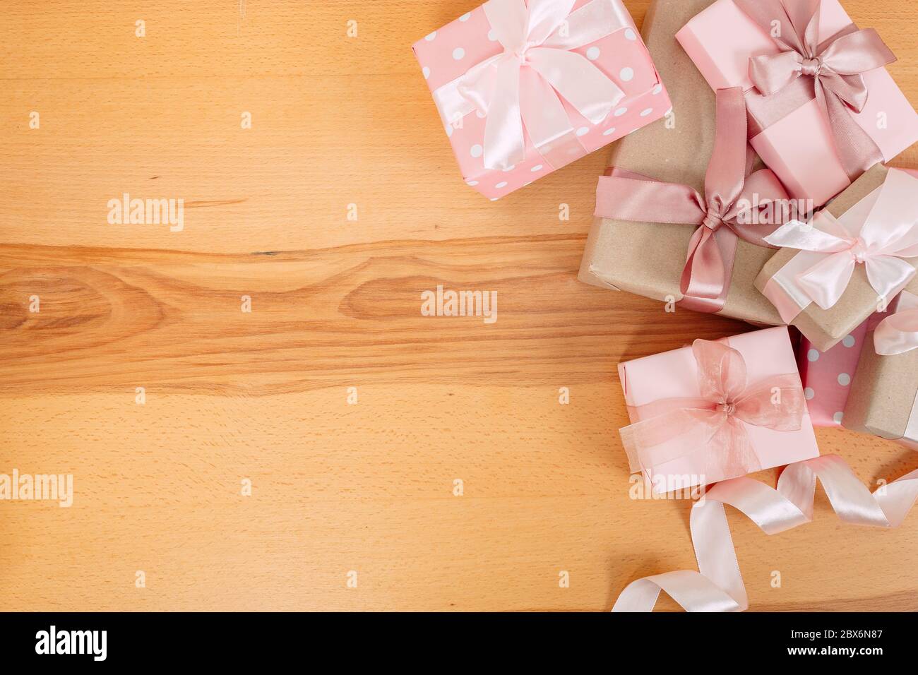 Set of beautiful gift boxes with pink bows on a wooden table. Stock Photo