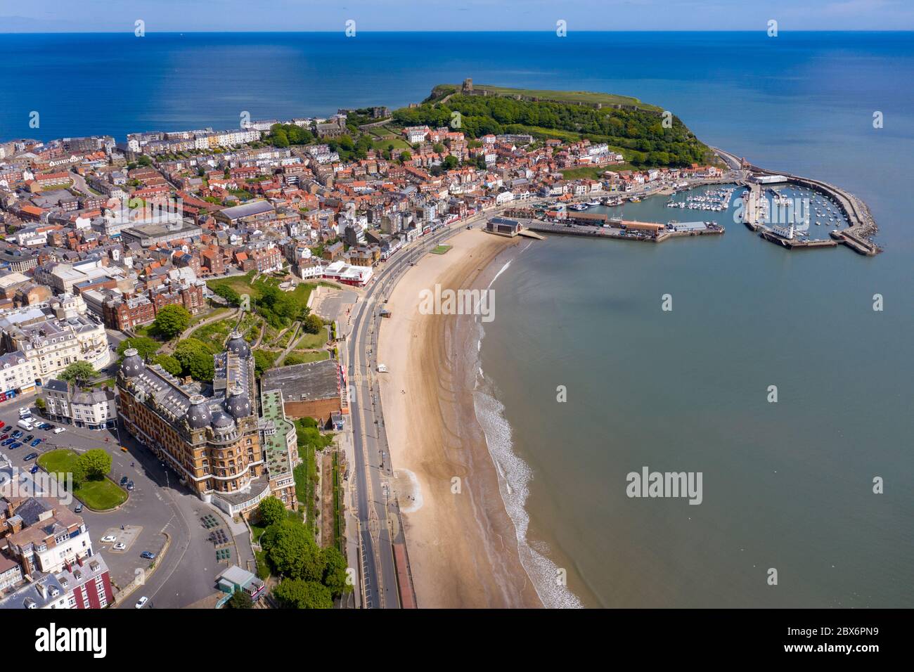 Aerial photo of the town centre of Scarborough in East Yorkshire in the UK showing the coastal beach and harbour with boats and the Scarborough Castle Stock Photo