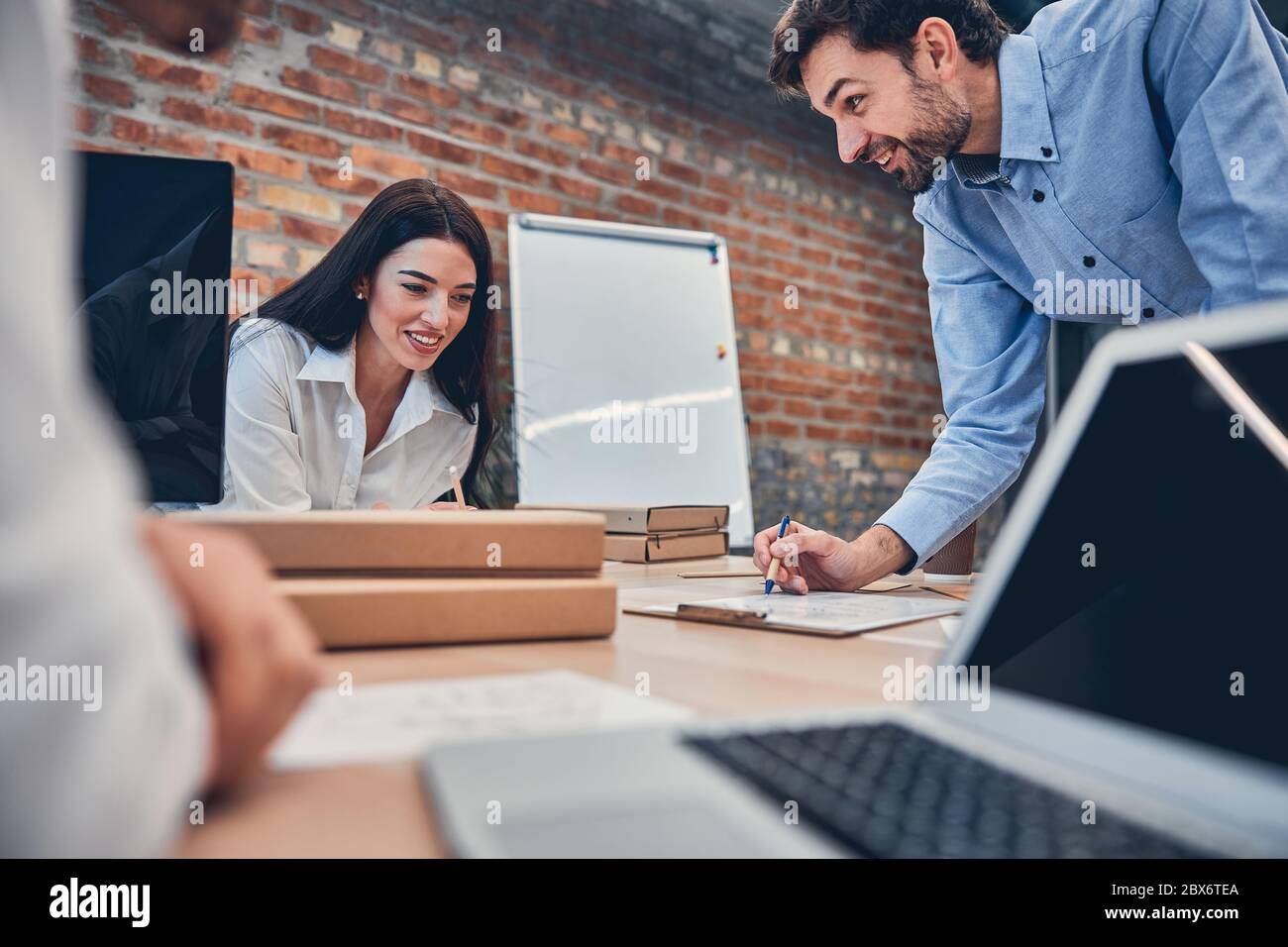 Happy coworkers writing notes while working together Stock Photo