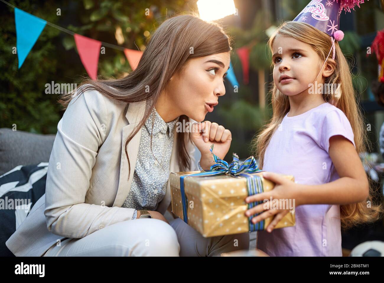 Young mom with daughter on birthday party Stock Photo