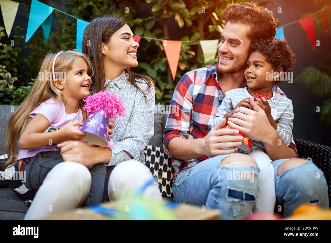Cheerful man and woman with children on birthday party having fun and smiling Stock Photo