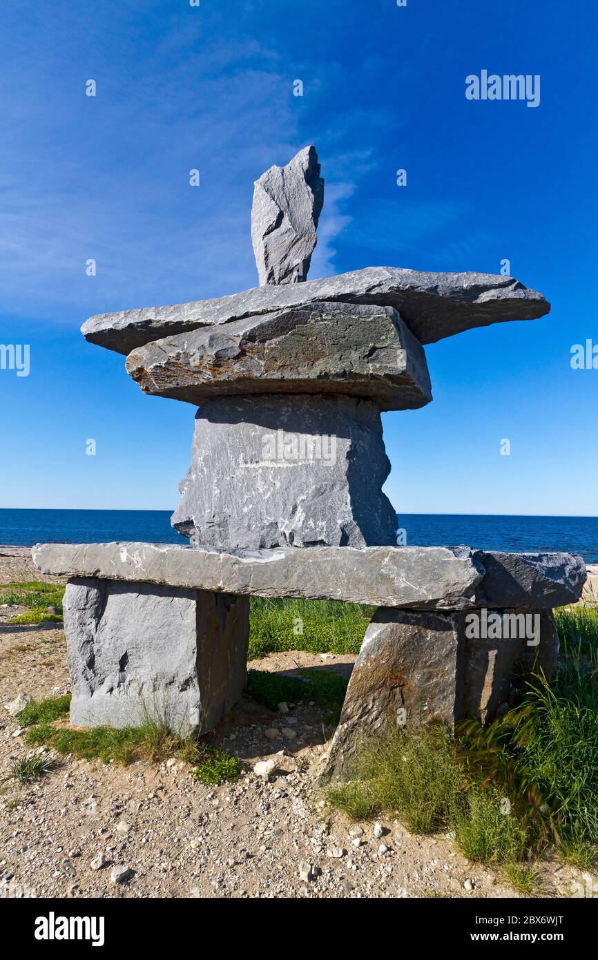 Inukshuk sitting on the beach of Hudson Bay in Churchill, Manitoba, Canada. An inukshuk is a stone landmark built by humans in the Arctic Stock Photo