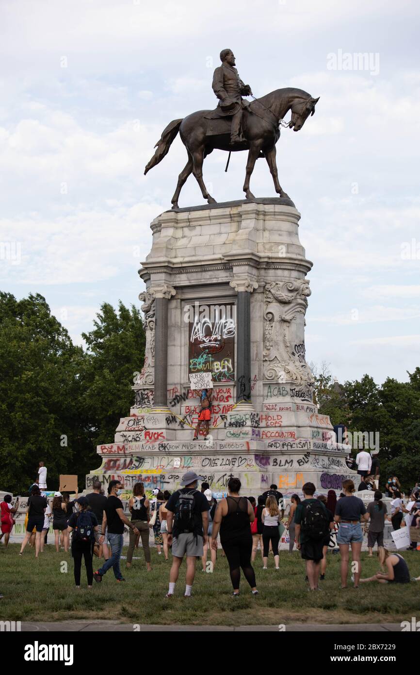 Protests at the statue of Confederate General Robert E. Lee in Richmond with graffiti covering the marble base. Racial injustice and police brutality. Stock Photo