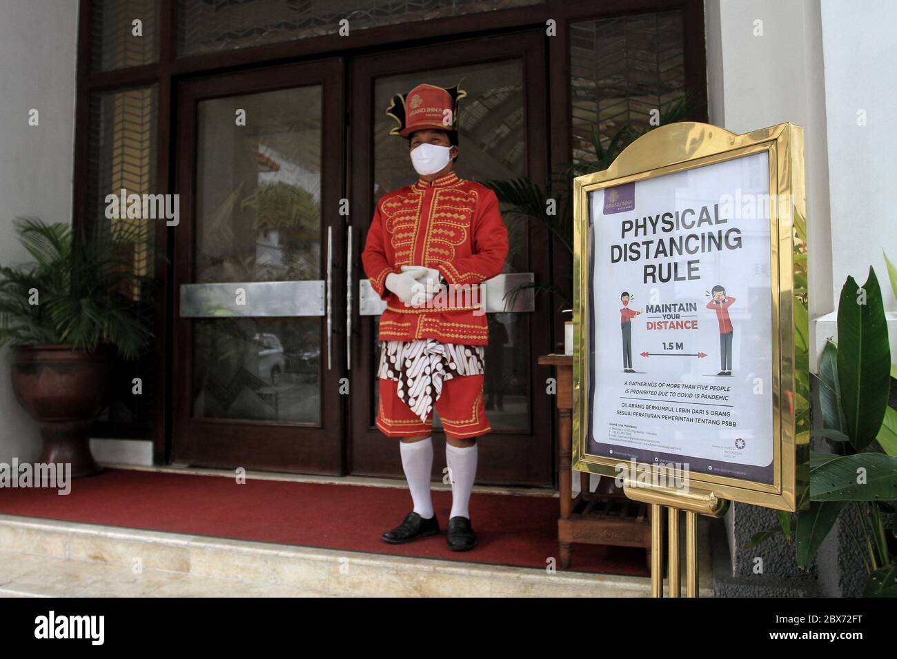 Yogyakarta Indonesia 05th June 2020 A Employee Of The Grand Inna Malioboro Hotel Yogyakarta Wear Javanese Traditional Clothes And A Face Mask At The Entrance Hotel In Yogyakarta Indonesia June 5 2020