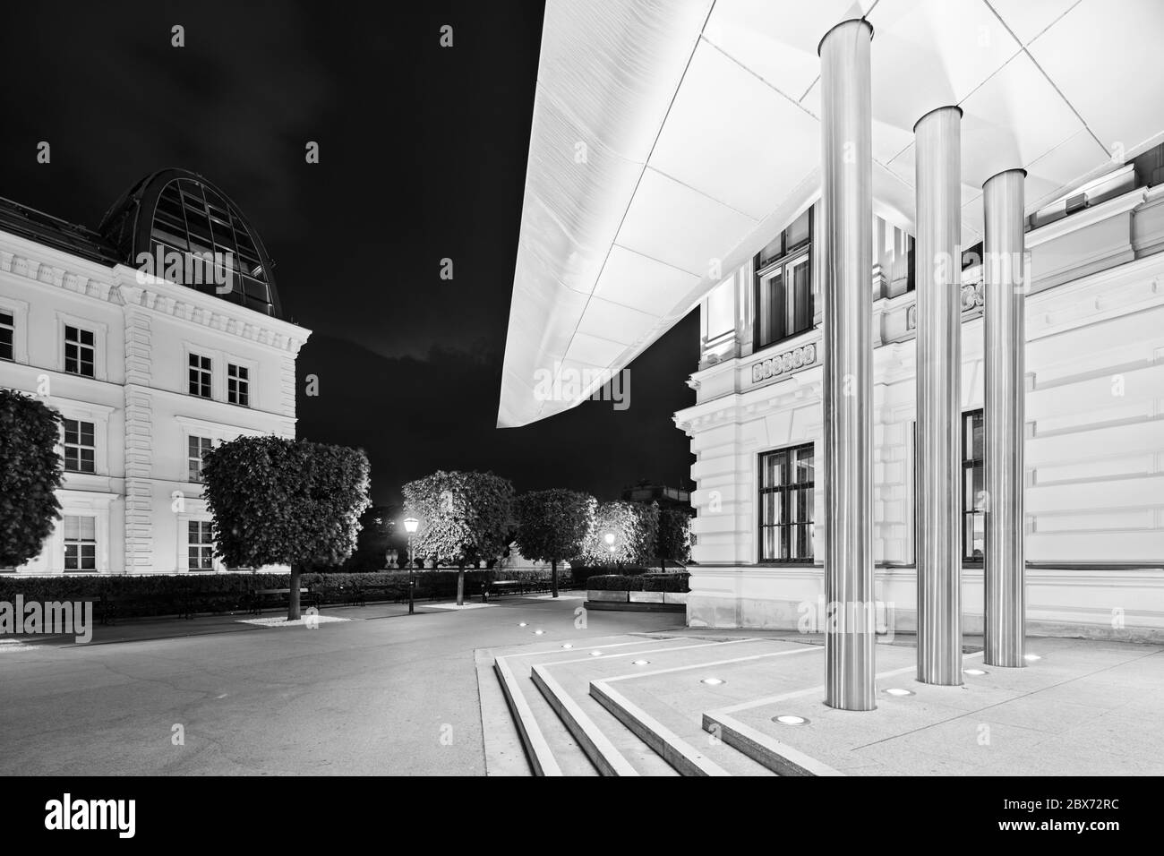 Entrance of the Albertina building with its modern roof at night in Austria in black and white Stock Photo