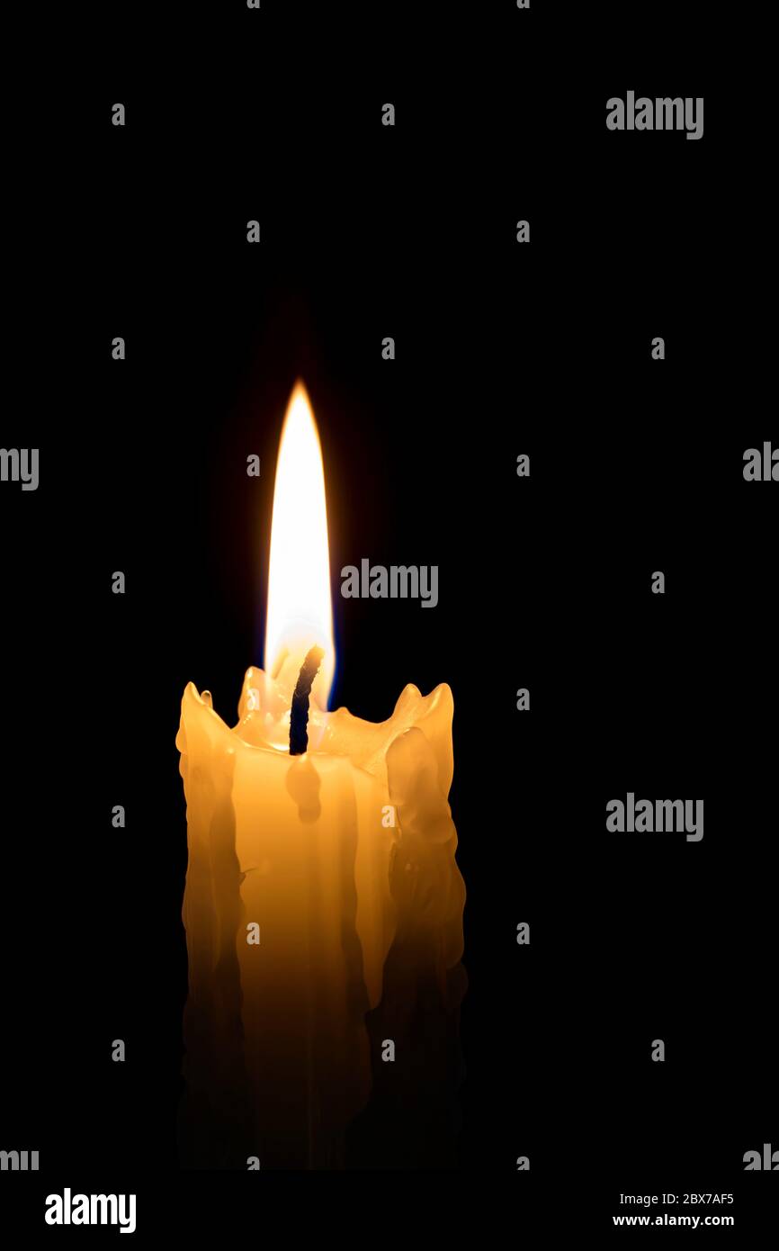 Candle flame with black background. Single candle burning, with melted