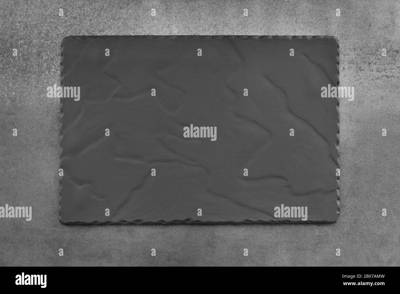 Empty gray slate plate, top view, over stone background. Stock Photo