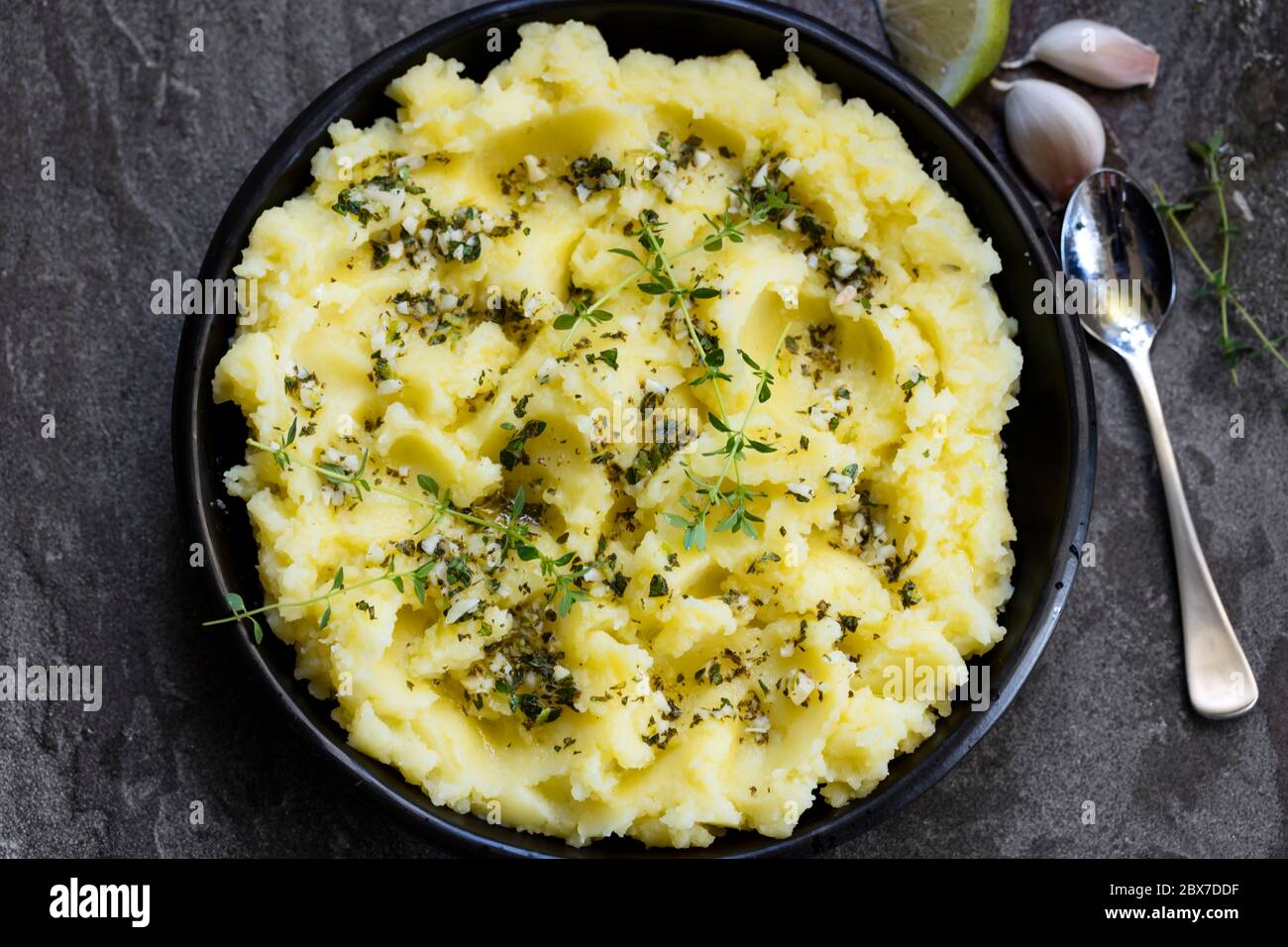 Potato mash with olive oil, garlic, lemon, and herbs. Top view on dark