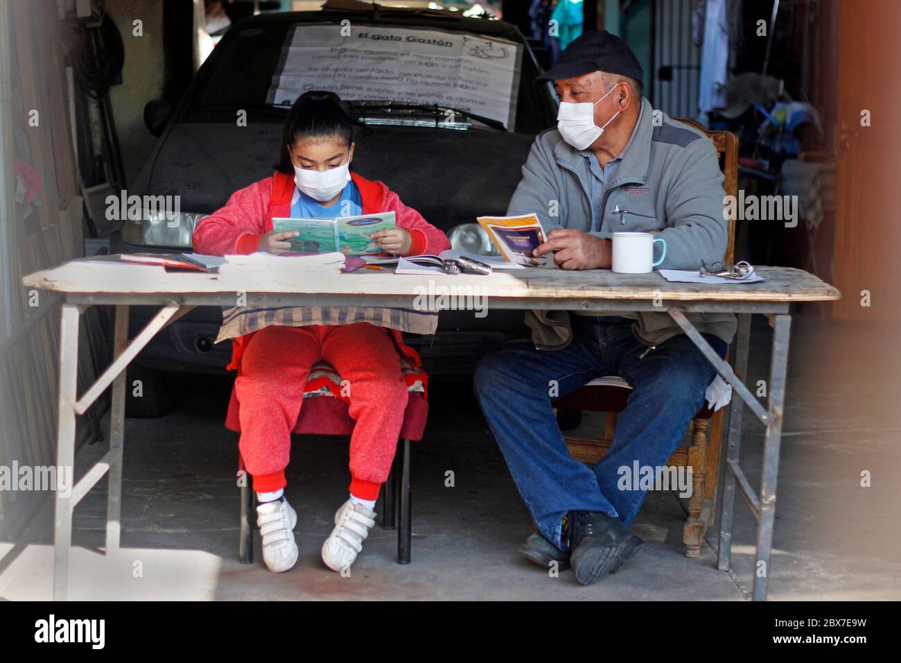 Santiago, Chile. 5th June, 2020. A girl studies with her grandfather in the garage of her home in the midst of the total quarantine decreed by the government to prevent the spread of Covid-19. More than 4 million schoolchildren in Chile are at home due to the suspension of face-to-face classes suspended since March, a measure adopted by the Government to help control the Covid-19 outbreak. Credit: Sebastian Silva/ZUMA Wire/Alamy Live News Stock Photo