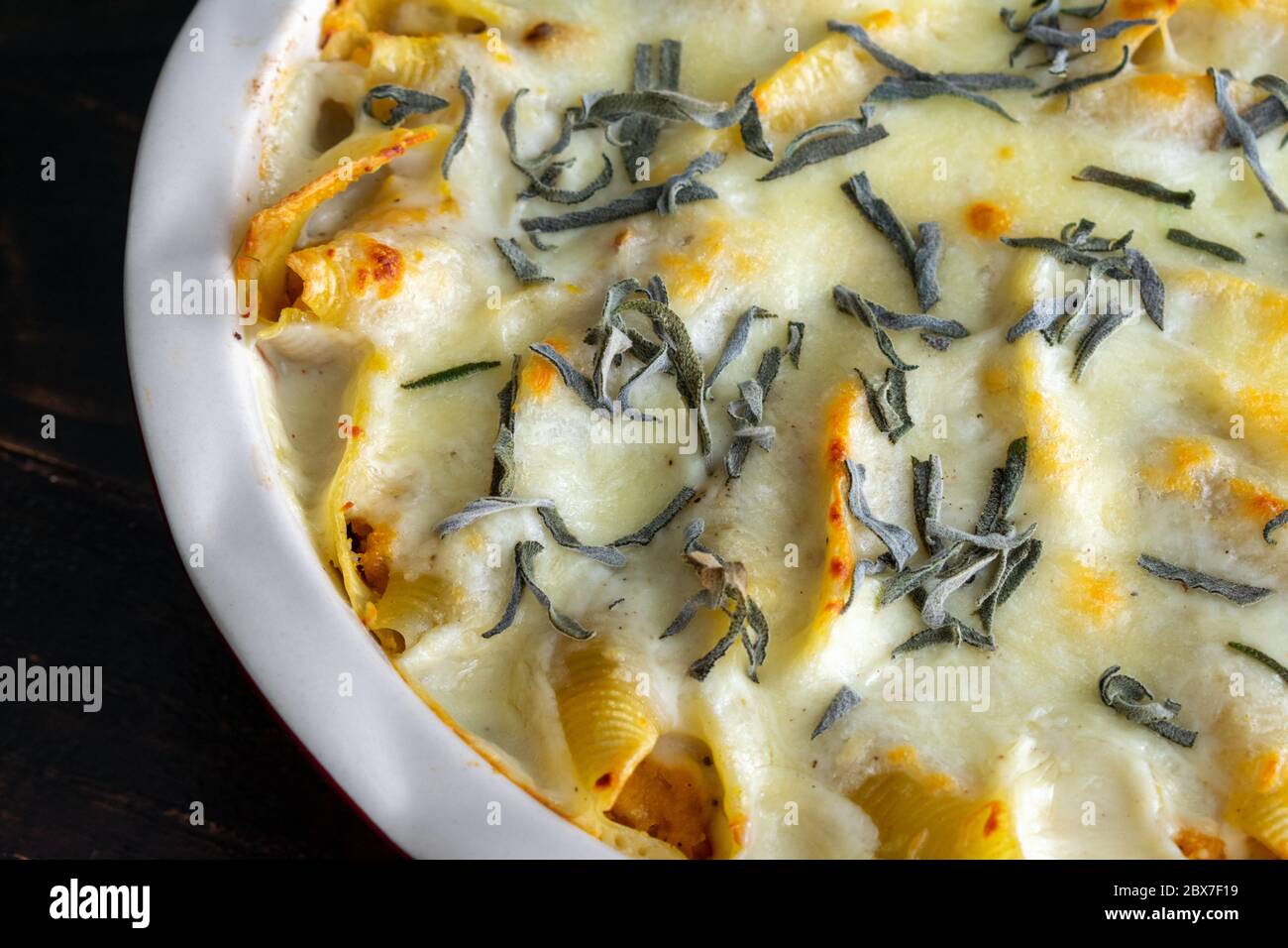 Butternut Squash Stuffed Shells: Jumbo pasta shells stuffed with butternut squash puree and topped with cream sauce, cheese, and sage leaves Stock Photo