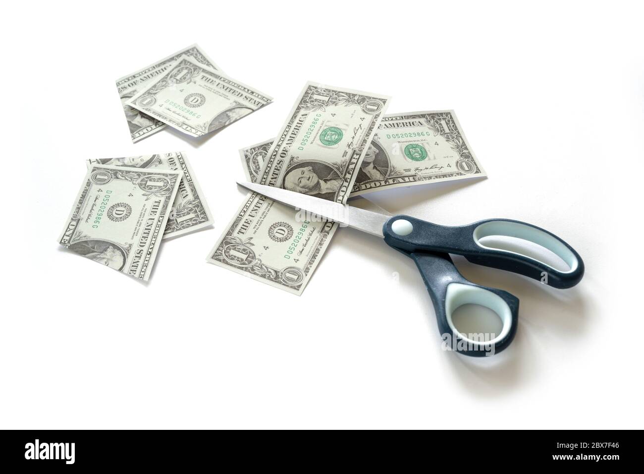 Business concept, one Dollar banknotes are cut with scissors, metaphor for income reduction during a financial crisis like coronavirus pandemic, white Stock Photo