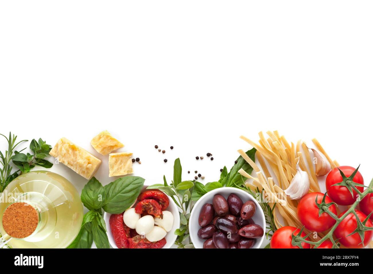 Italian food background over white.  Variety of ingredients, including olive oil, pasta, tomatoes, olives, herbs, parmesan and mozzarella. Stock Photo