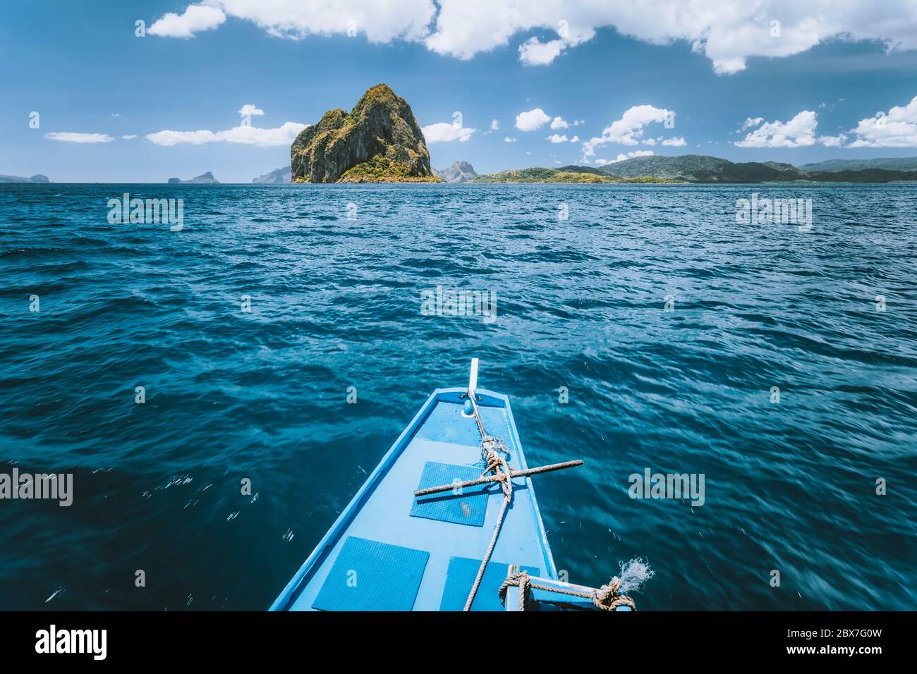 Boat approaching exotic island on tour trip in famous archipelago Bacuit El Nido, attractions