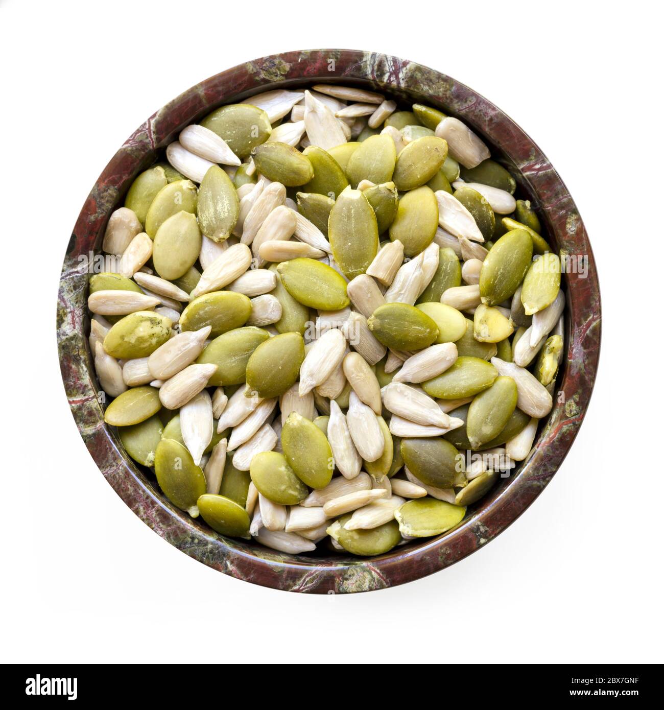 Sunflower and pumpkin seeds or pepitas in small stone bowl. Top view