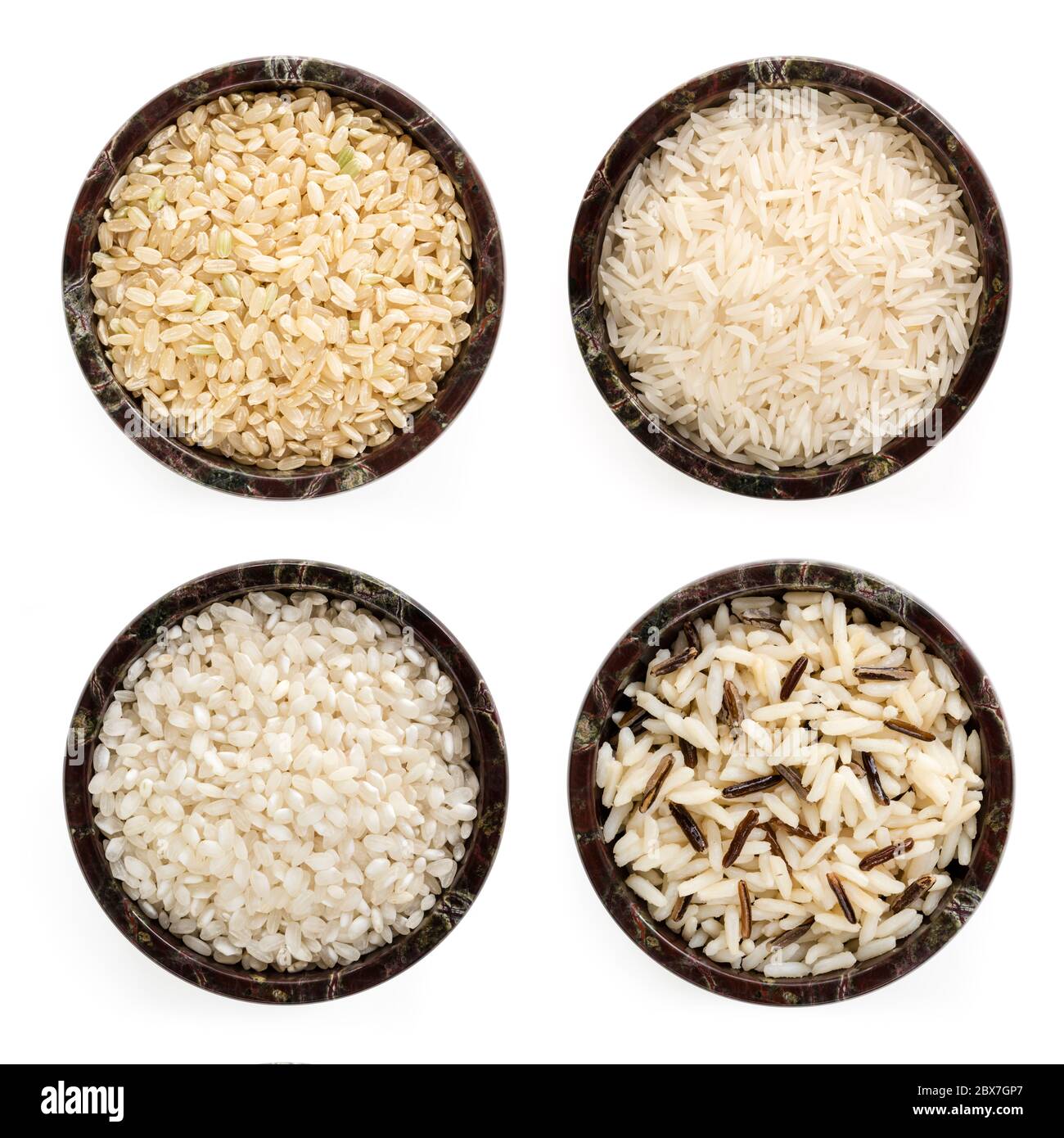 Rice varieties in stone bowls.  Top view, isolated.  Includes arborio, basmati, brown, long grain and wild. Stock Photo