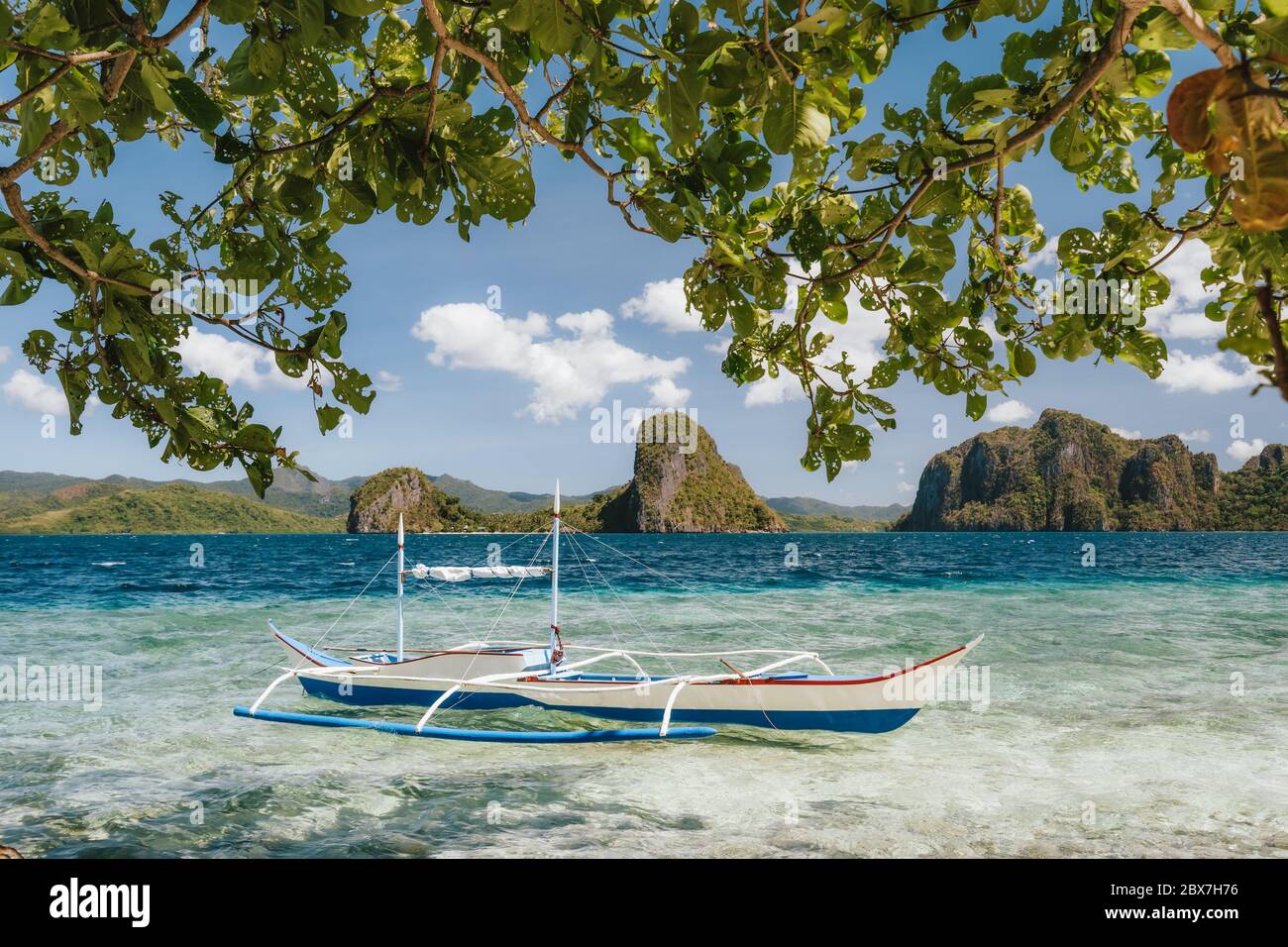 Banca boat in shallow blue water on Ipil beach of Pinagbuyutan Island