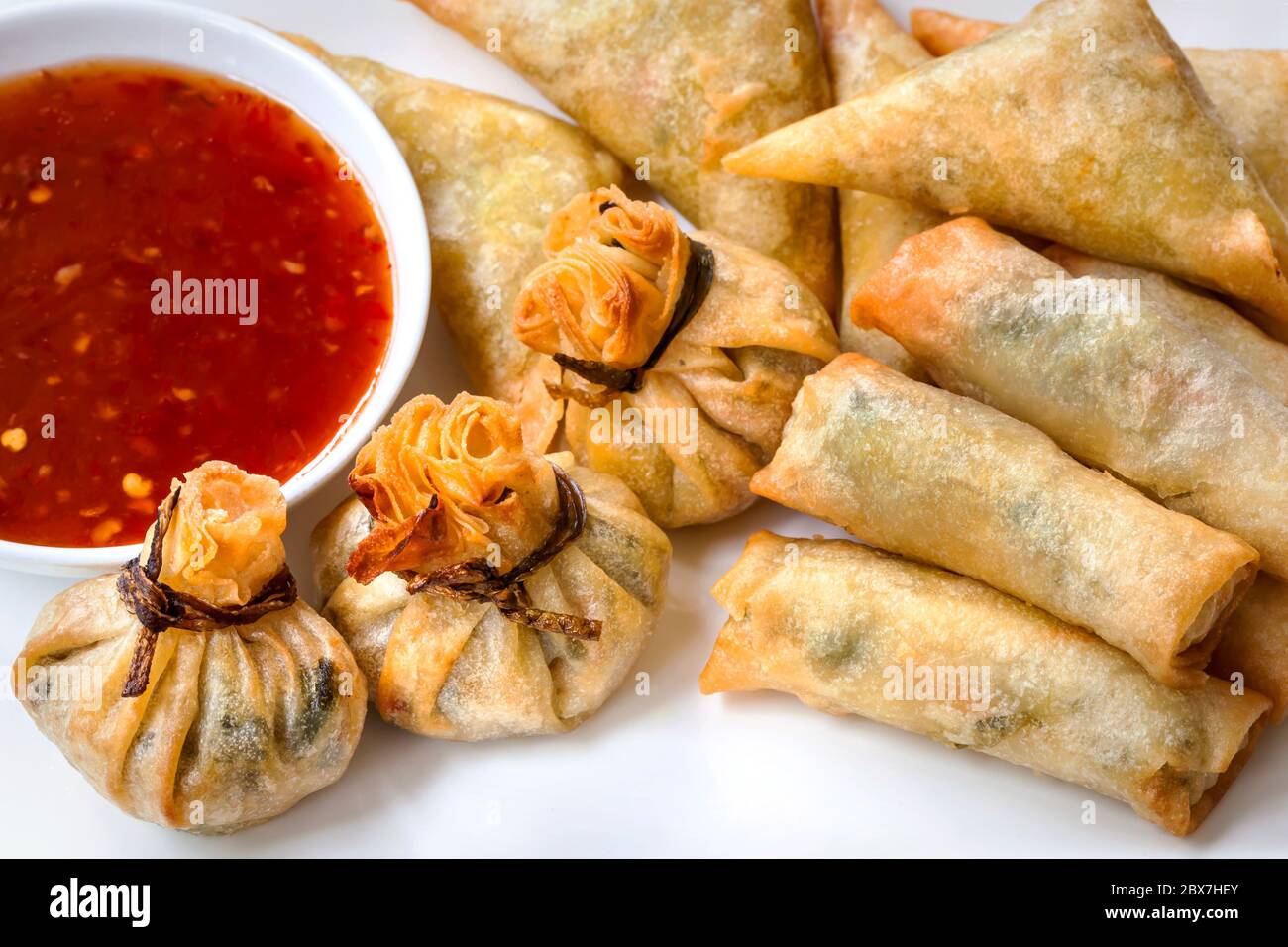 Asian appetizers with sweet chili sauce.  Spring rolls and money bags. Stock Photo