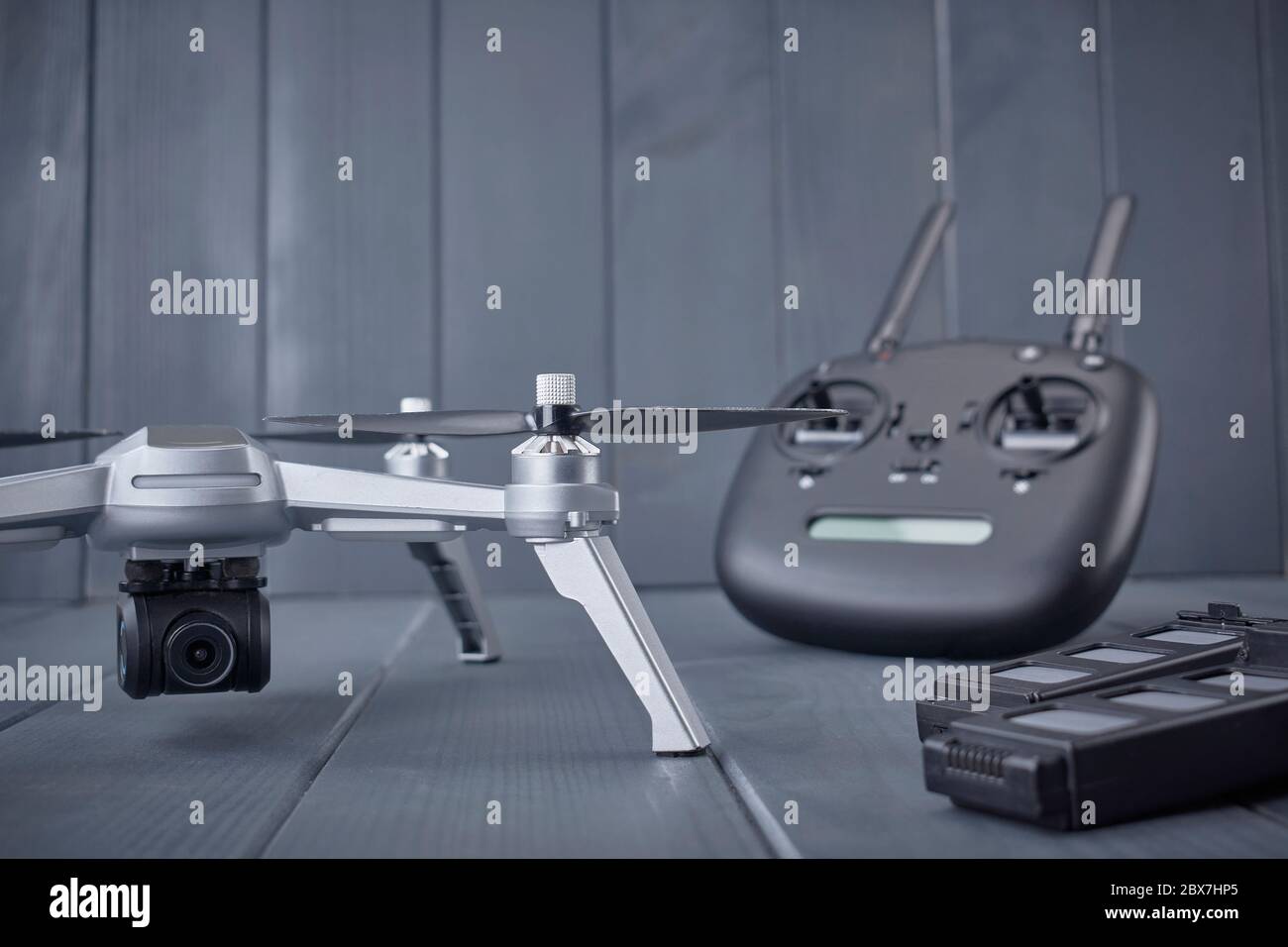 Close-up of propellers and batteries and high resolution camera of a four-engine drone with radio control equipment in the background Stock Photo