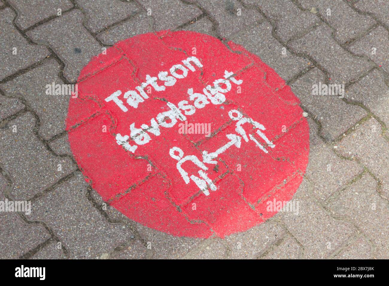 Tartson tavolsagot (keep distance) sign painted on ground at the entrance of Tesco supermarket during covid-19 coronavirus pandemic, Sopron, Hungary Stock Photo
