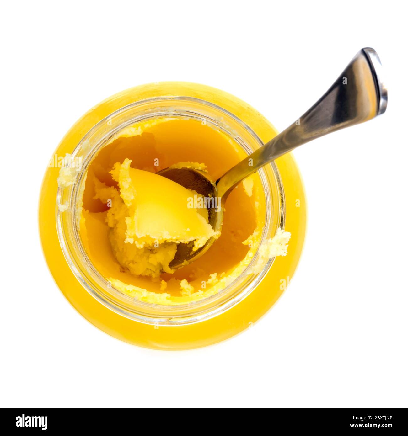 Ghee in jar with spool.  Top view, isolated on white.  Clarified butter from grass-fed cows. Stock Photo