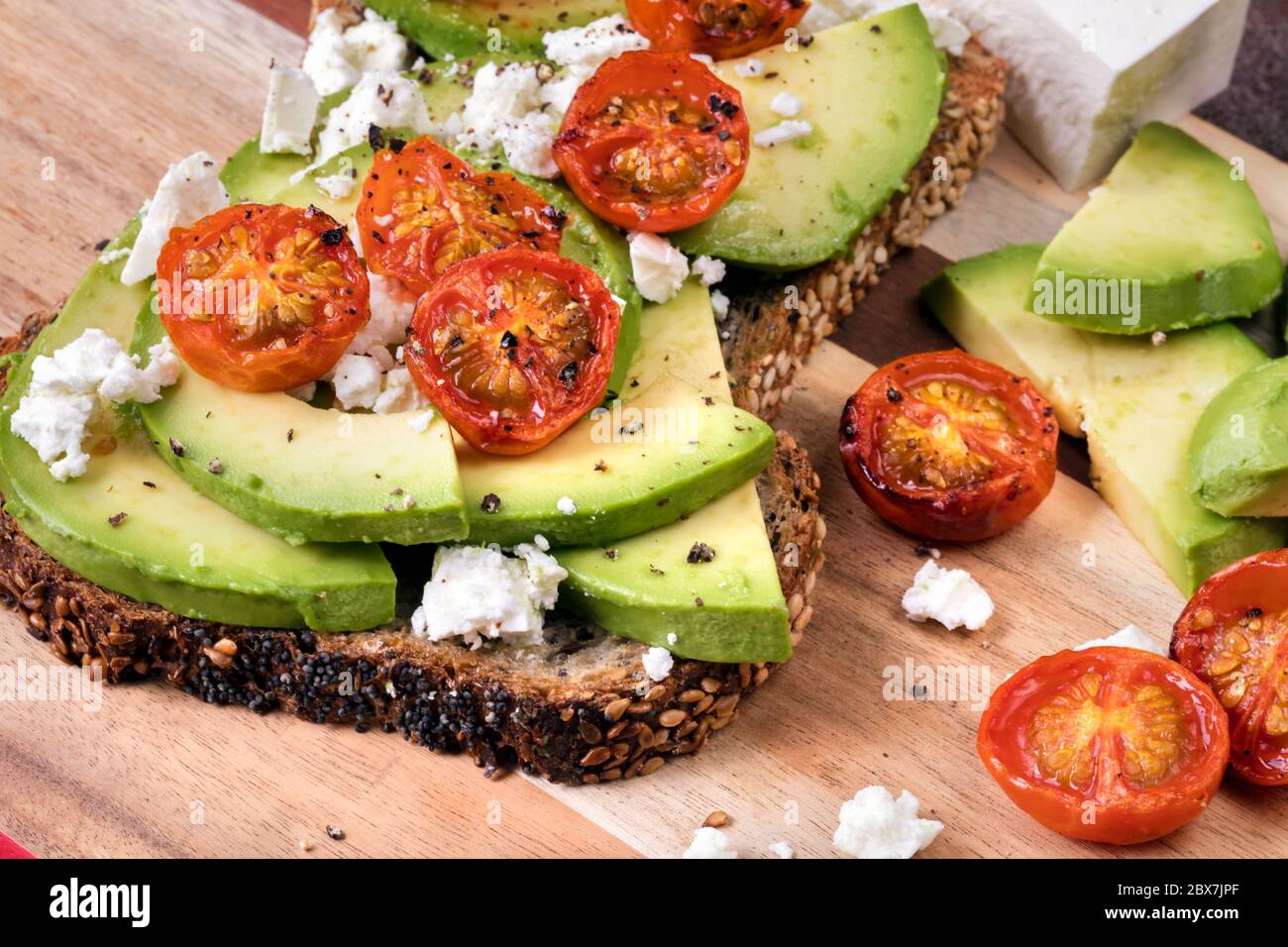 Avocado toast with roasted cherry tomatoes and feta cheese Stock Photo