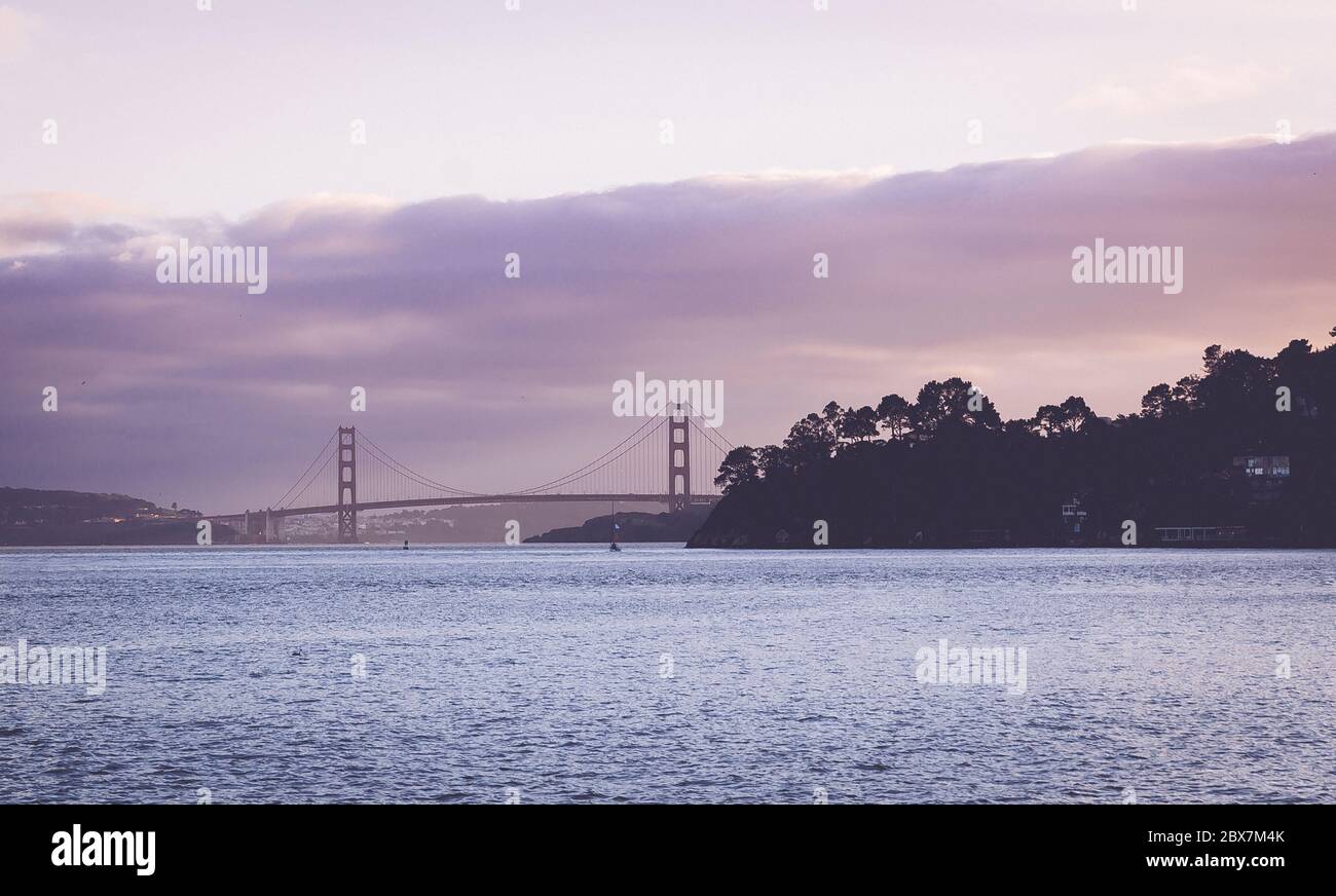 A breathtaking scene of the Golden Gate Bridge spanning the tranquil shoreline Stock Photo