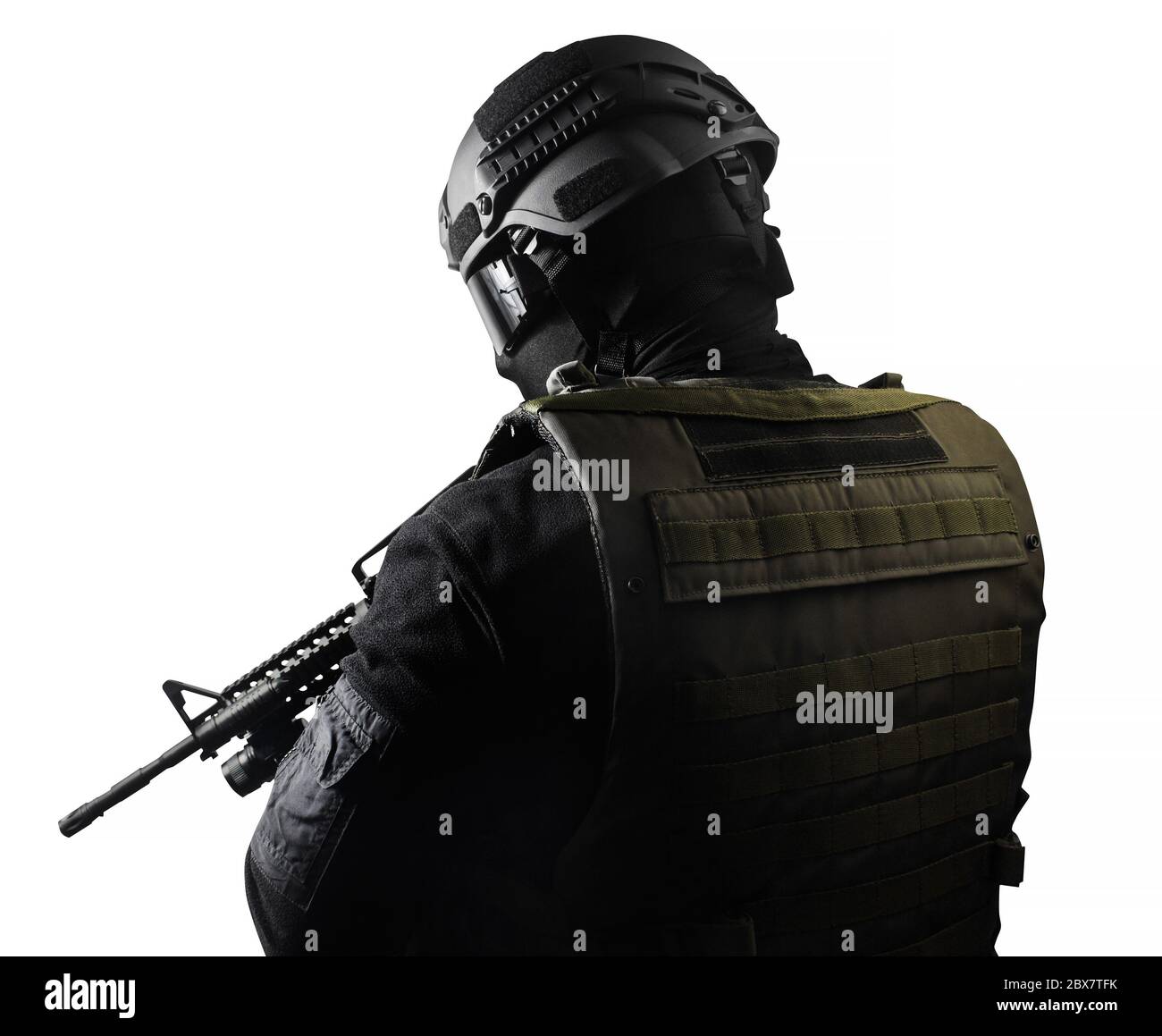 Isolated photo of a fully equipped swat soldier standing with rifle back view. Stock Photo