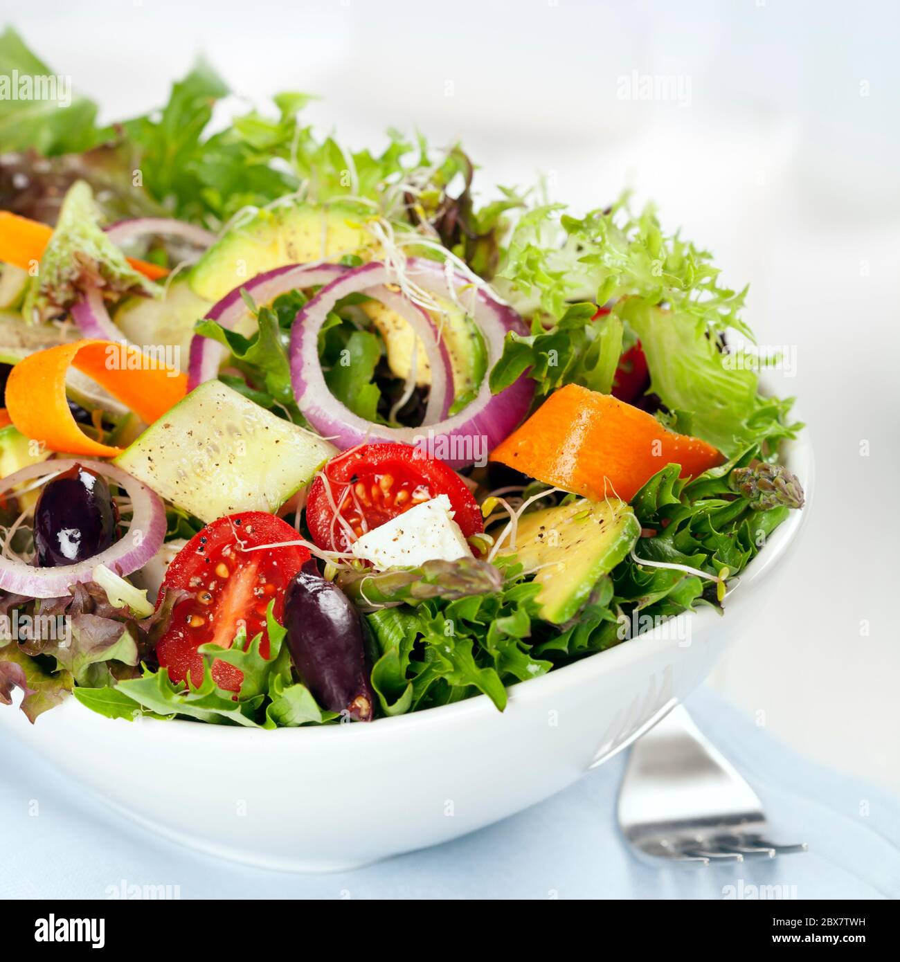 https://c8.alamy.com/comp/2BX7TWH/salad-in-white-bowl-mixed-greens-with-black-olives-tomatoes-and-lots-of-vegetables-2BX7TWH.jpg