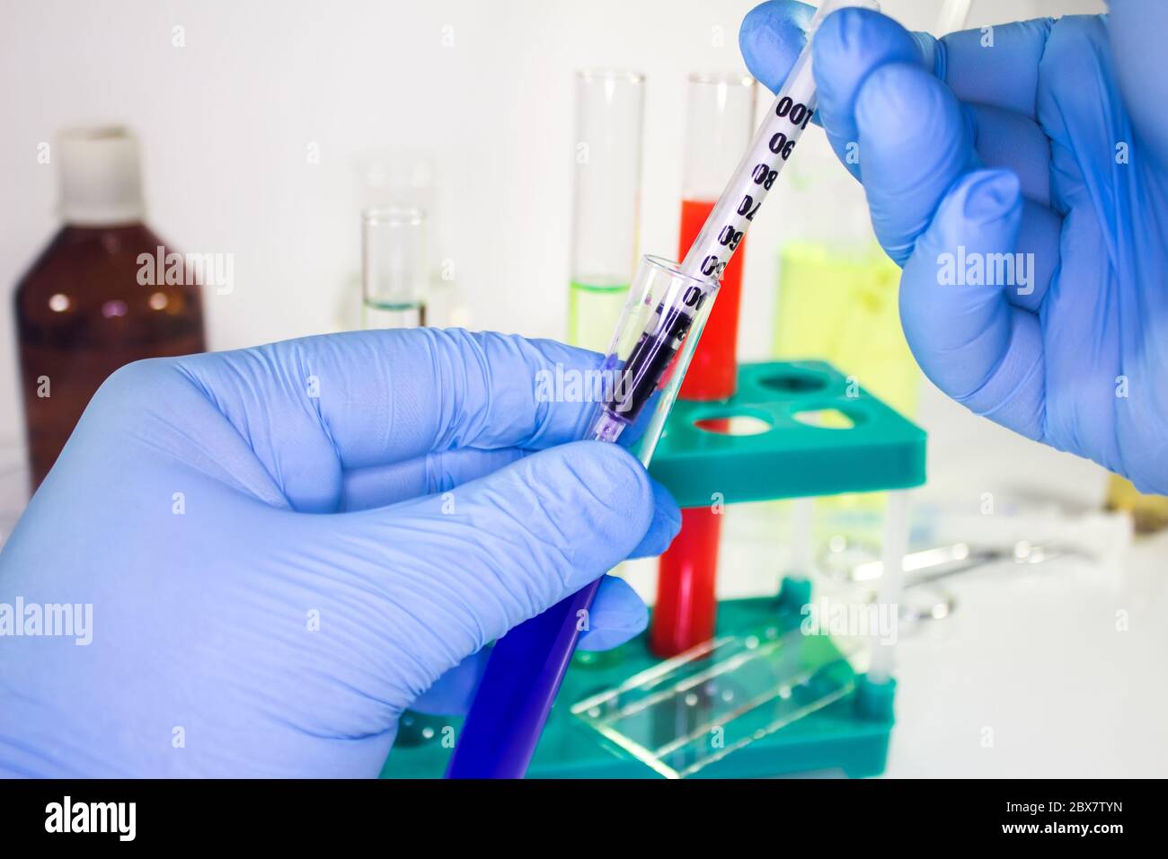 First person view hands in gloves holding test tube and syringe on ...