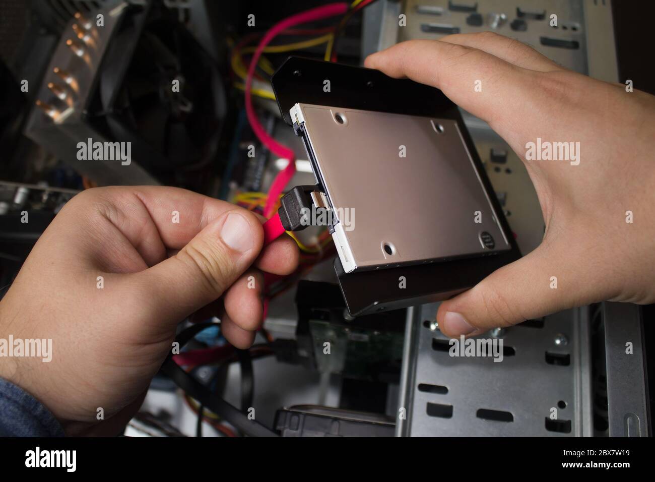 First person view hands connecting SSD drive cables to a motherboard Stock Photo Alamy
