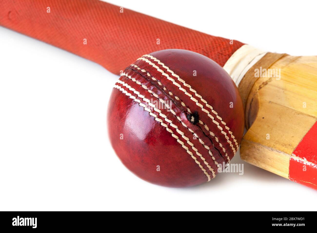 Old cricket bat and cricket ball, over white background. Stock Photo
