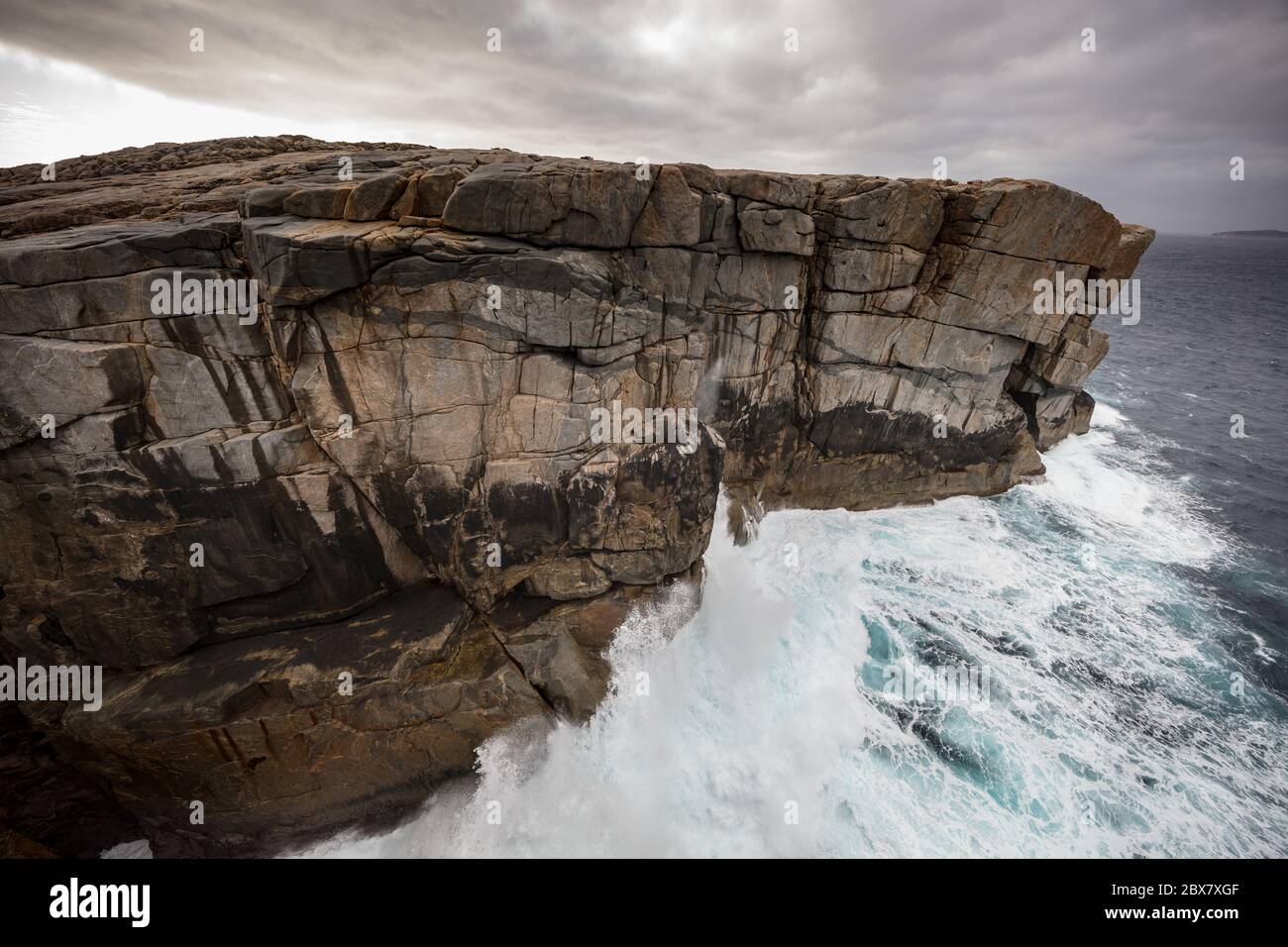 Dramatic early morning light and crashing waves at the Gap rock formation in Torndirrup National Park, Albany, Western Australia Stock Photo