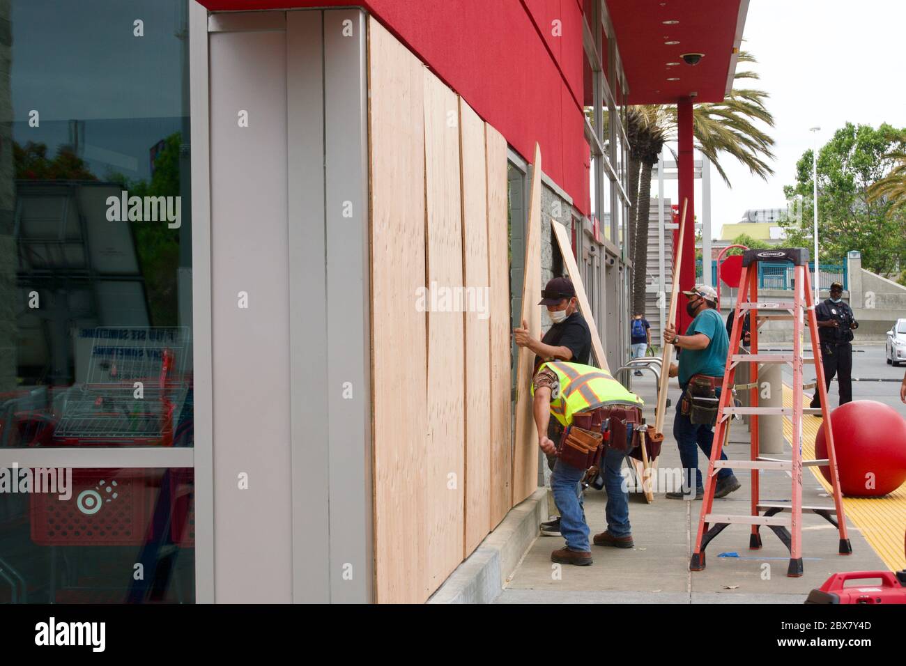 Workers board up Target store windows to safeguard against looters after the killing of George Floyd by a police officer. Oakland, CA Stock Photo