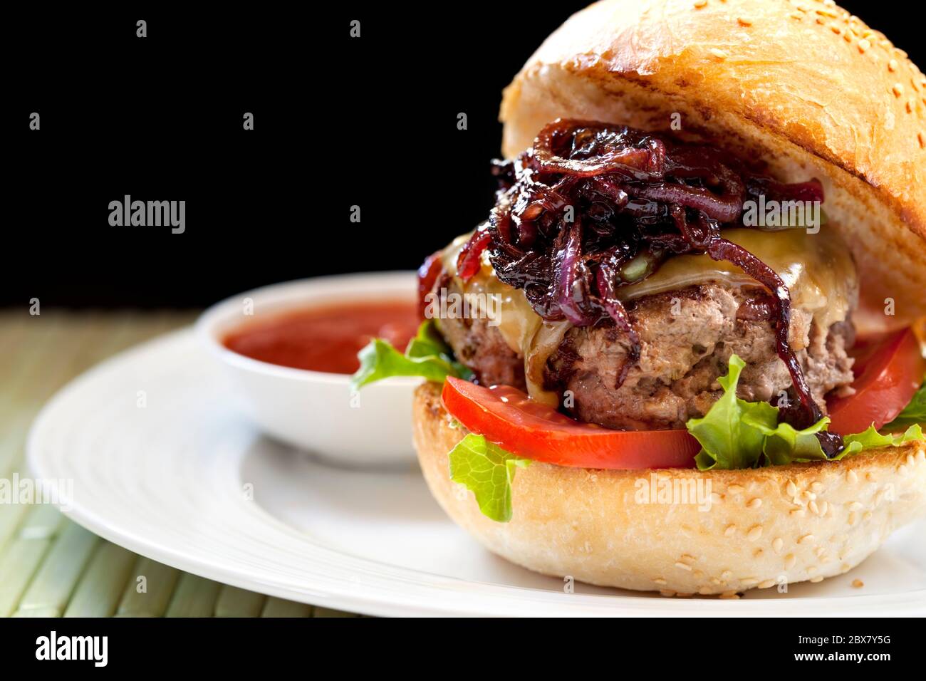 Healthy hamburger.  Lean meat with salad, tomatoes, low-fat cheese and caramellised onions. Stock Photo