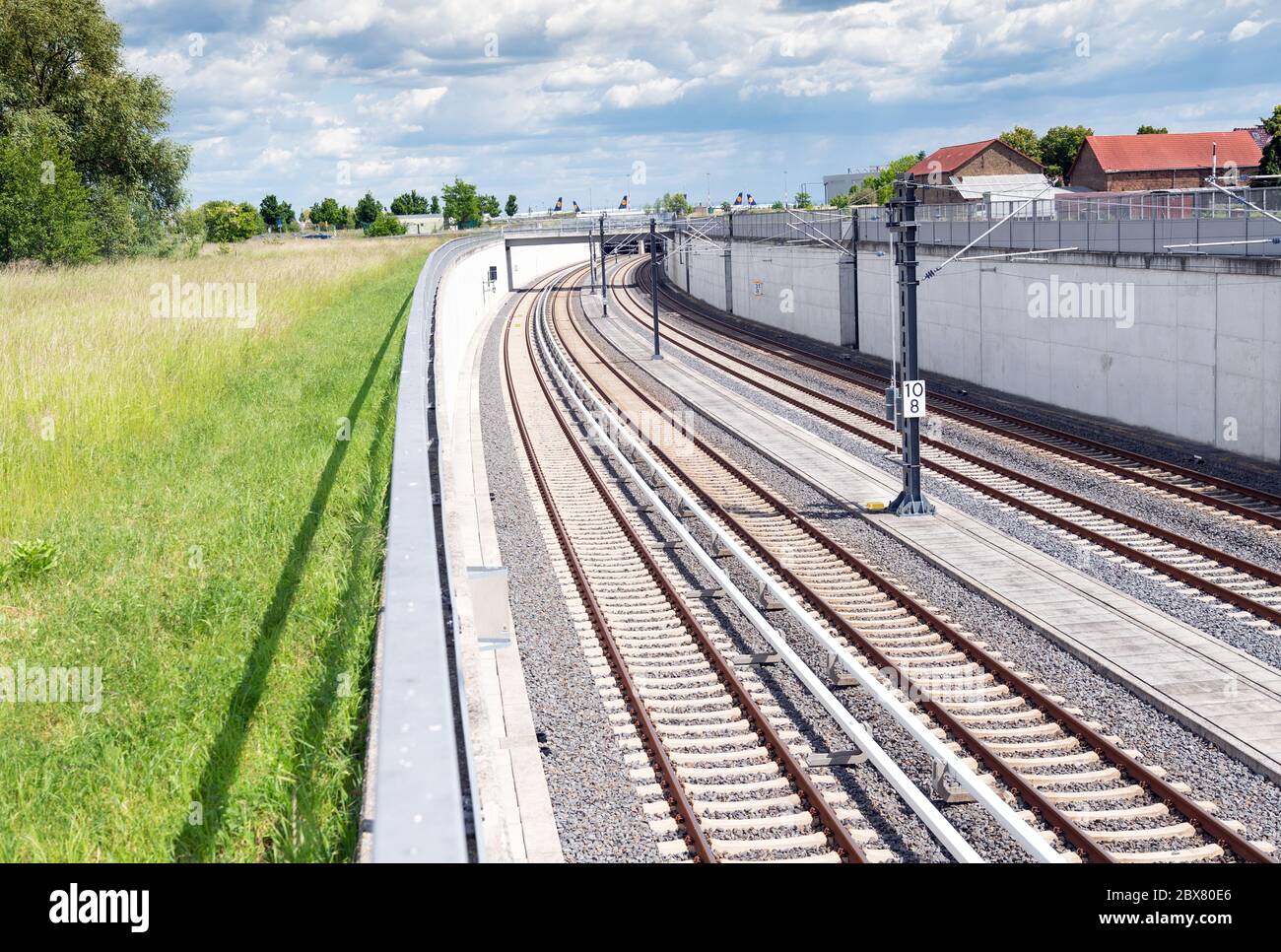 https://c8.alamy.com/comp/2BX80E6/potsdam-germany-02nd-june-2020-the-rails-of-the-s-bahn-l-and-the-regional-railway-lead-into-a-tunnel-to-the-underground-station-of-the-capital-airport-in-the-background-off-the-tarmac-there-are-aircraft-of-the-airline-lufthansa-credit-soeren-stachedpa-zentralbildzbdpaalamy-live-news-2BX80E6.jpg