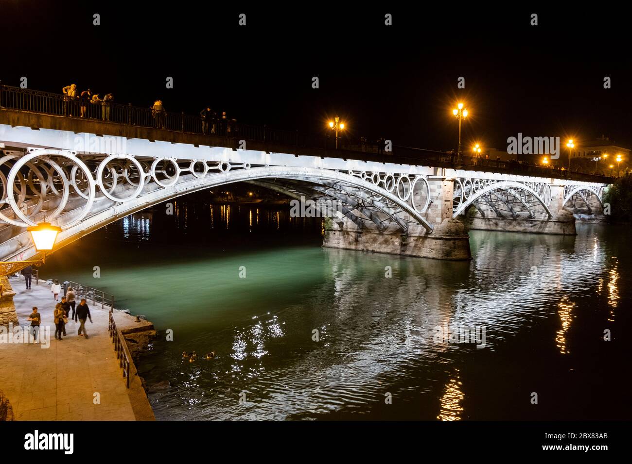 Triana bridge and its characteristic lighting. Seville, Andalusia ...