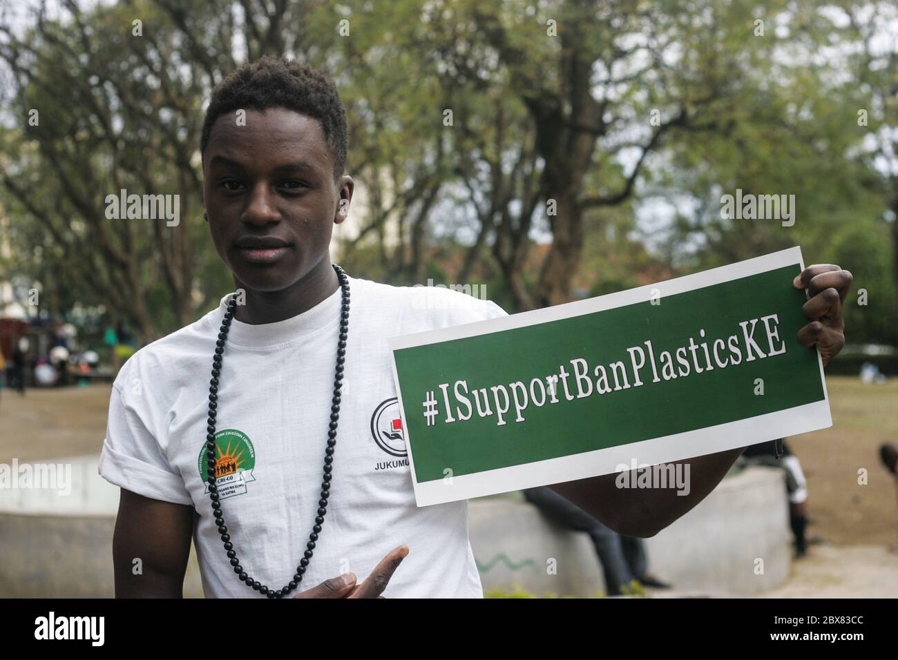 A man holds a placard saying 'I Support Ban Plastics' during the
