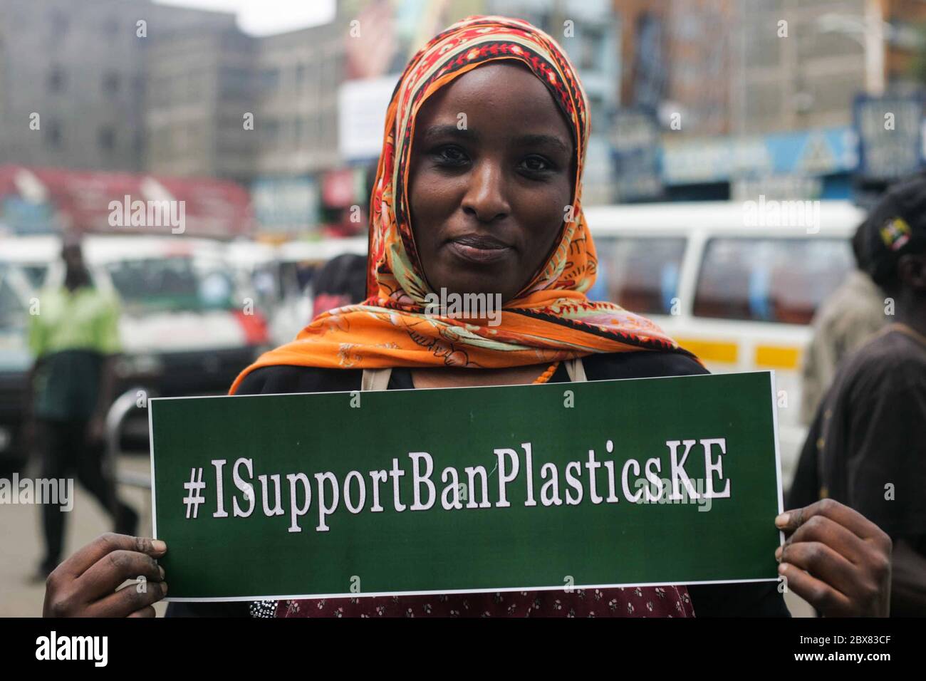 A woman holds a placard saying 'I Support Ban Plastics' during the