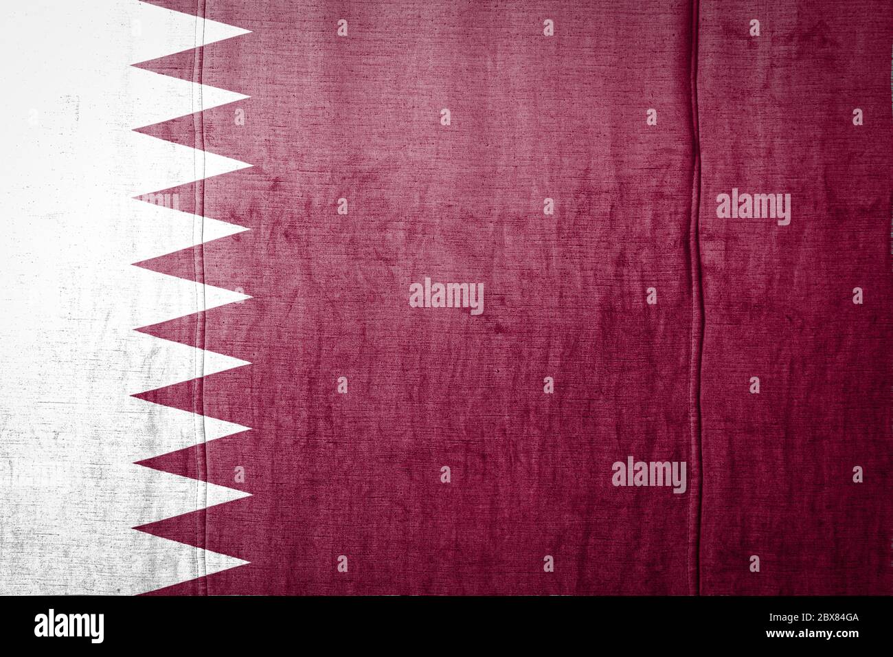 National flag of Qatar depicting in paint colors on old textile. Flag