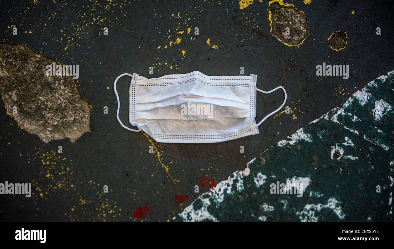 Medical face mask on the floor in the street. Improperly discarding the ...