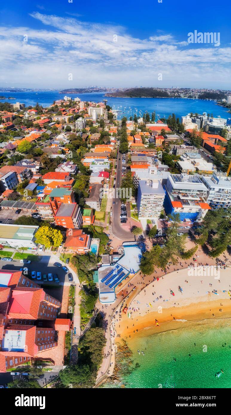 Great local sandy beach in Manly suburb of Sydney on Pacific ocean cost - vertical aerial panorama with view of distant Sydney harbour and city CBD. Stock Photo