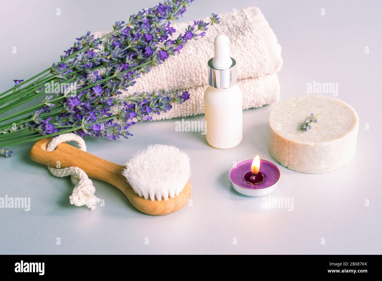 Spa products, soap, face brush and towel, lavender flowers on white background. Stock Photo