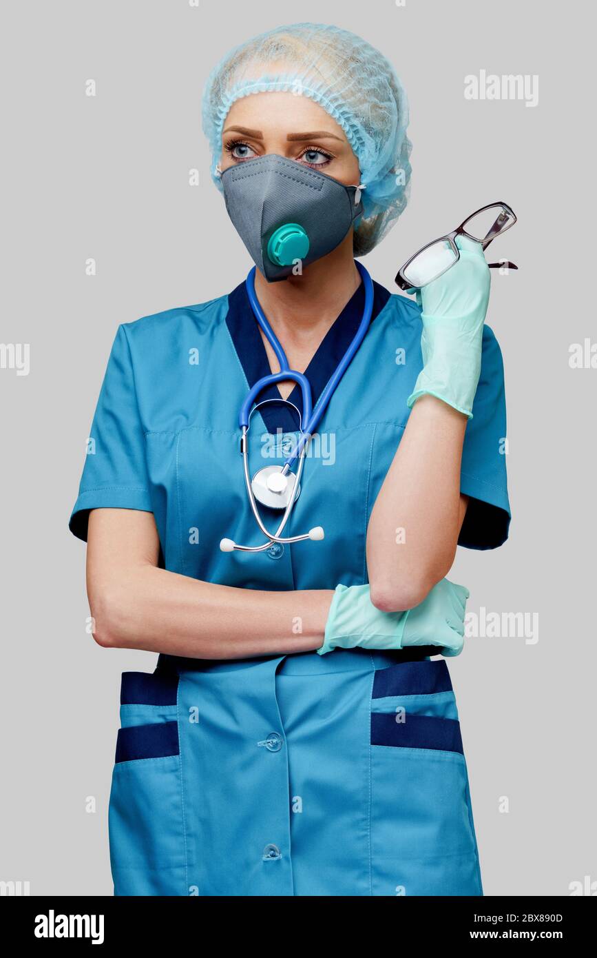 female doctor with stethoscope wearing protective mask and latex gloves ...