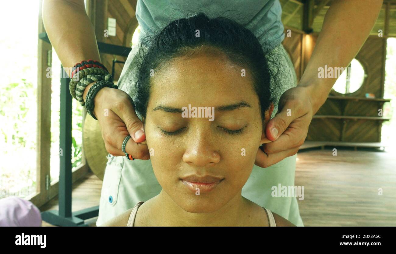young thai facials close up face portrait of young gorgeous and relaxed Asian Indonesian woman  receiving traditional facial Thai massage with male hands working her ears  Stock Photo - Alamy