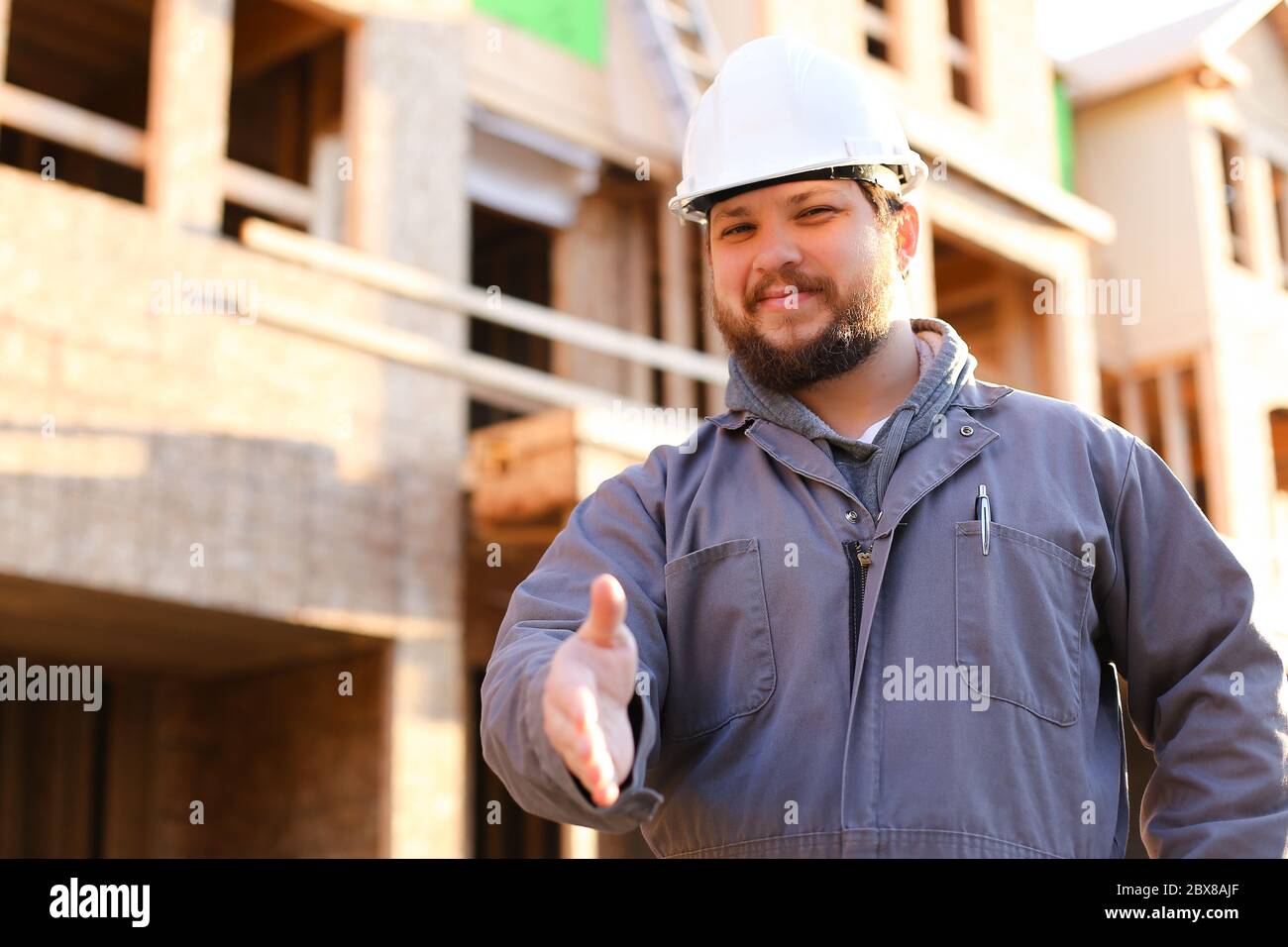 Caucaisan foreman wearing hardhat giving hand for shaking on ...