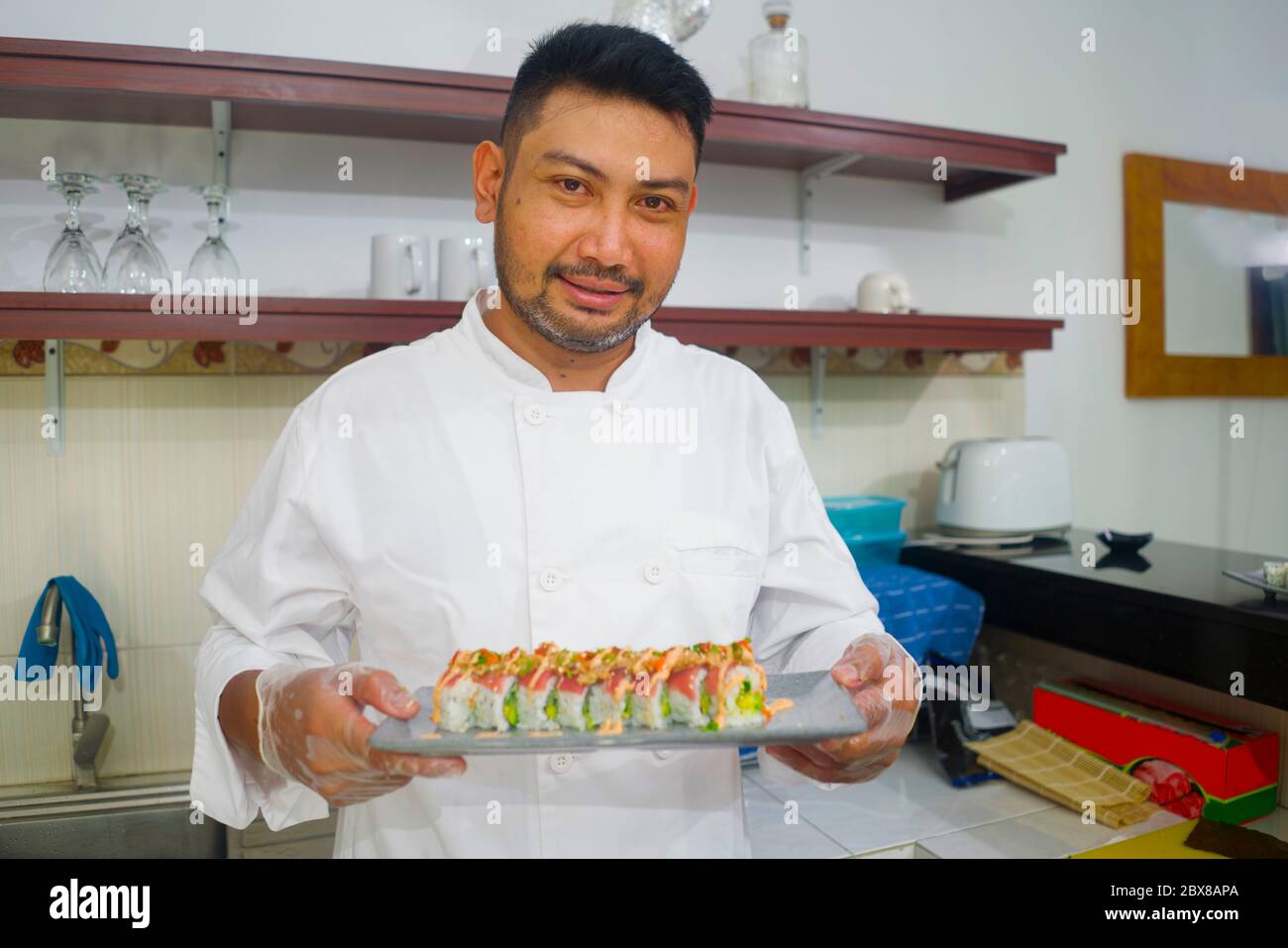 https://c8.alamy.com/comp/2BX8APA/lifestyle-portrait-of-asian-home-cook-man-or-professional-chef-cooking-in-clean-kitchen-showing-traditional-japanese-sushi-roll-dish-happy-and-proud-i-2BX8APA.jpg