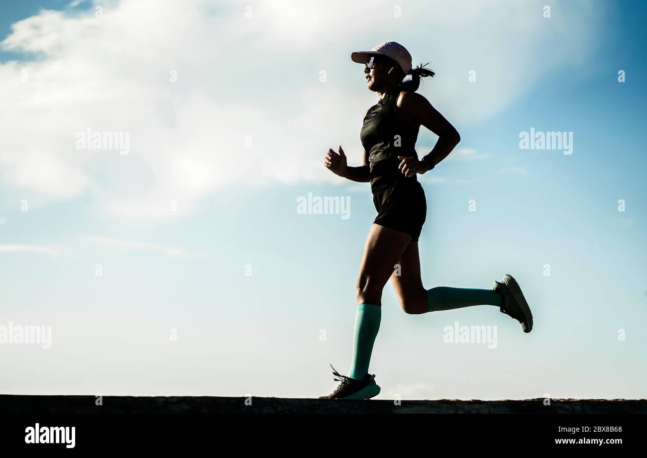 dynamic silhouette of young attractive and athletic woman in compression running socks jogging