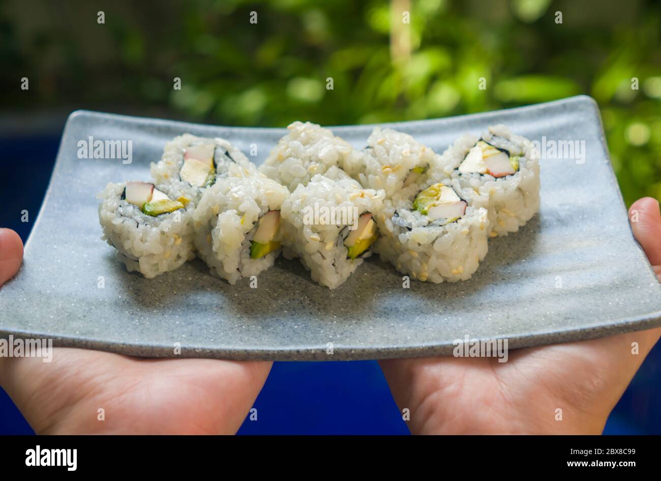 Japan Gourmet Cuisine Hands Presenting Delicious And Delicate Dish Of Japanese Sushi Rolls In Grey Slate In Traditional Healthy Asian Food And Creat Stock Photo Alamy